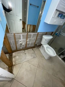 Bathroom water damage with removed drywall and exposed plumbing after a leak in a Lakewood Ranch, Florida home.
